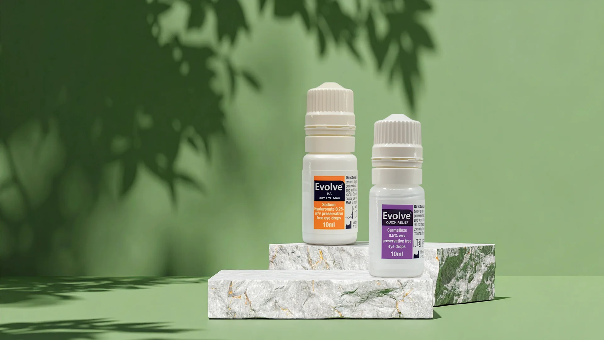 Evolve Dry Eye Max and Quick Relief bottles on a marble plinth against a green backdrop