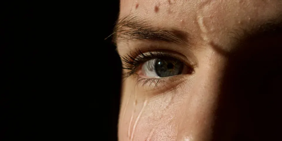 Close-up of a human eye with tears forming