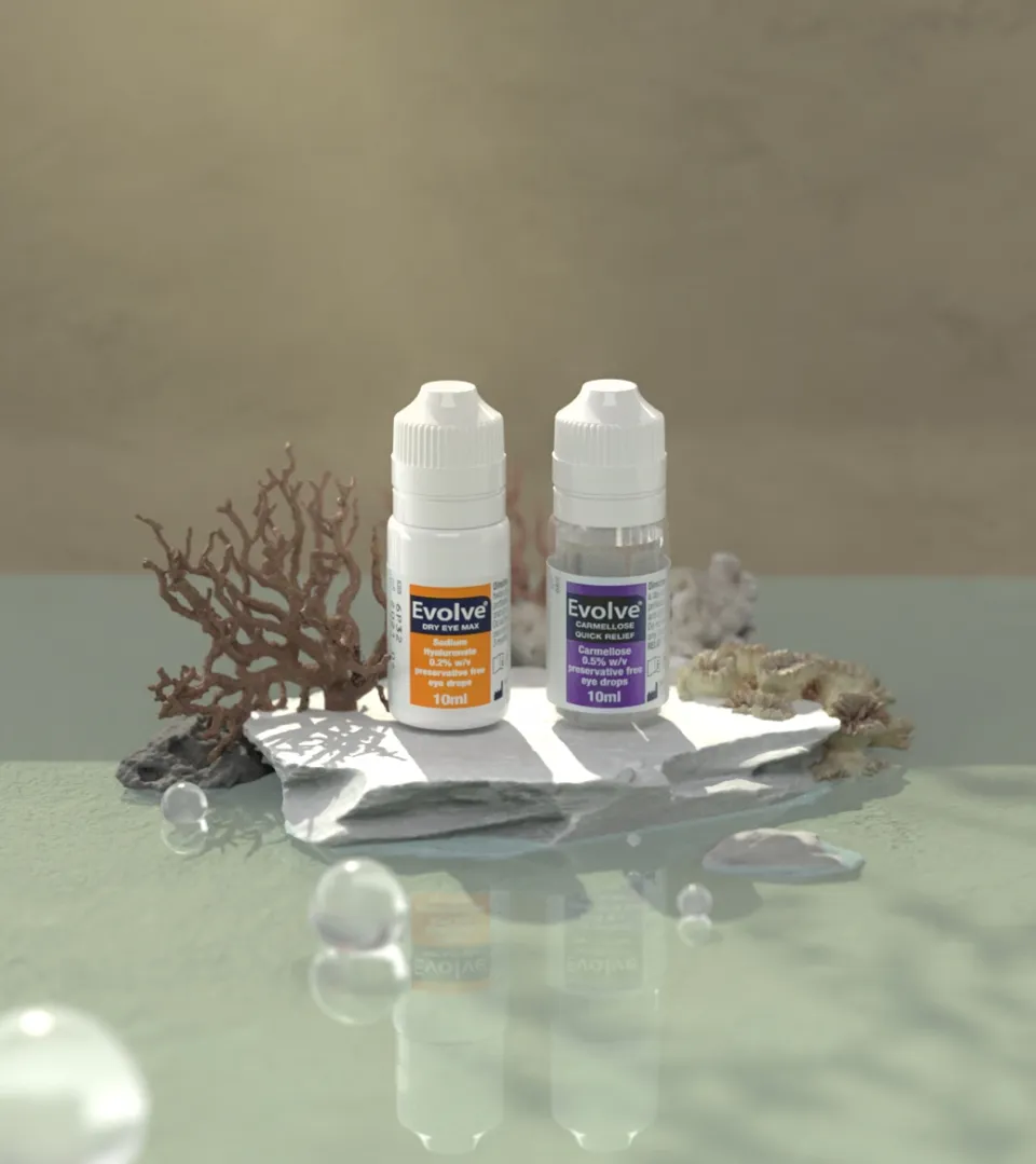 Evolve Dry Eye Max and Carmellose bottles styled with coral on a slate surface