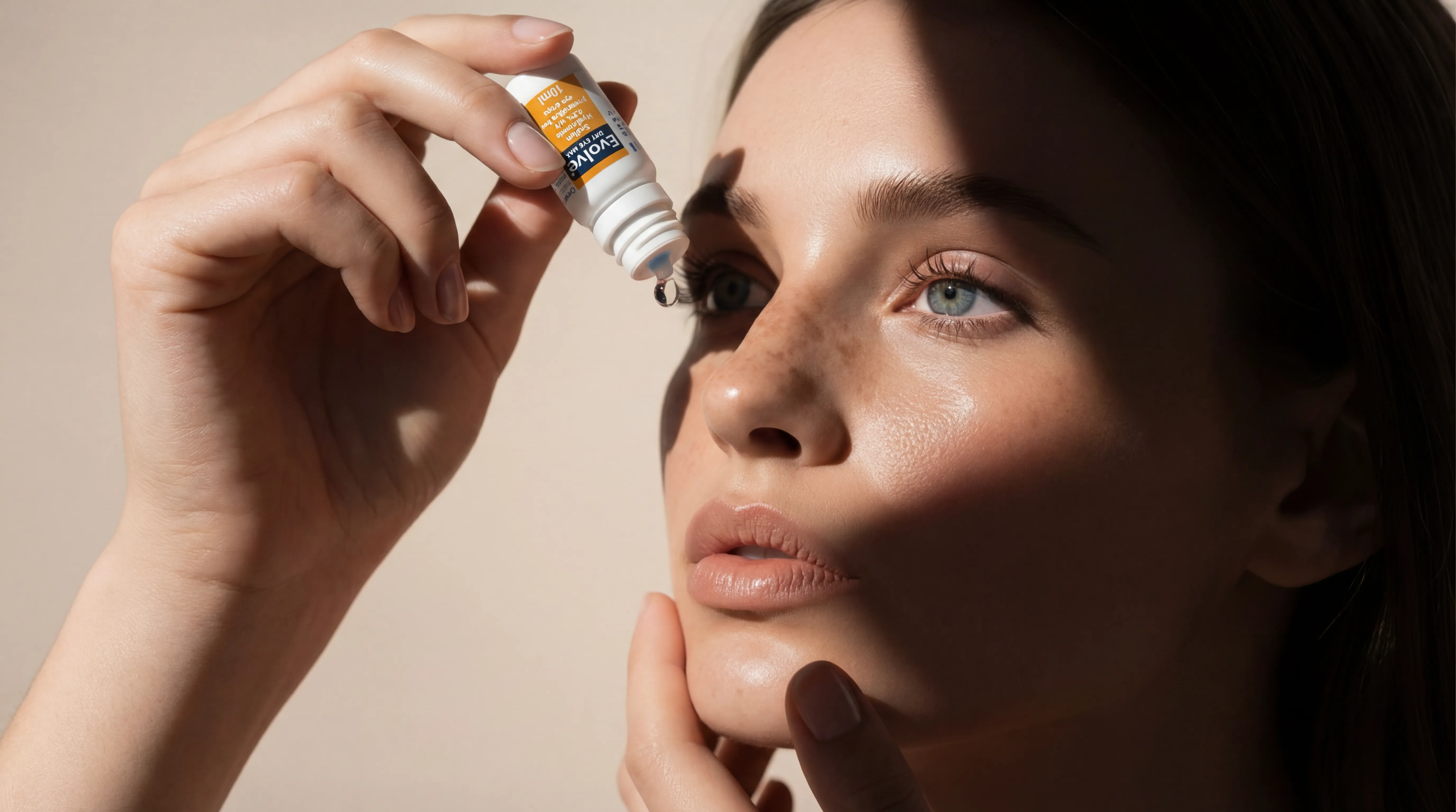 Young woman administering a drop of Evolve eye drops